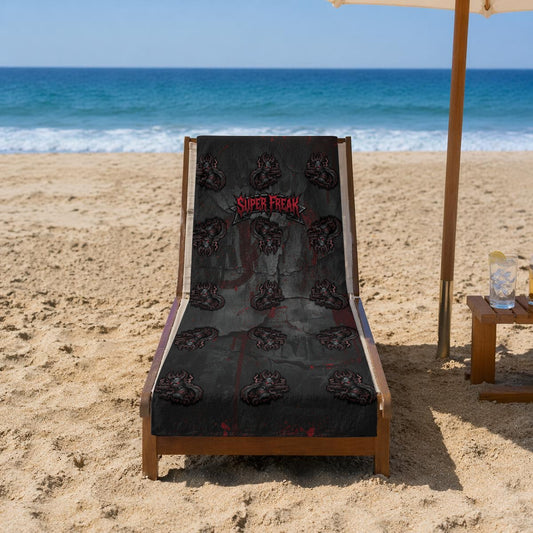 Beach Towel featuring repeat pattern of creepy mascot. Featured front facing, on a wooden folding beach lounger. Ready for sun bathing or drying off.
