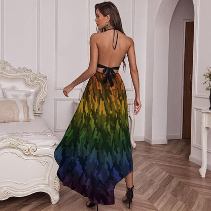 A woman stands in a bedroom wearing a backless maxi dress Halloween costume with a tie waist and a multicolor camouflage-style print that transitions from yellow and green at the top to dark blue and purple at the hem.